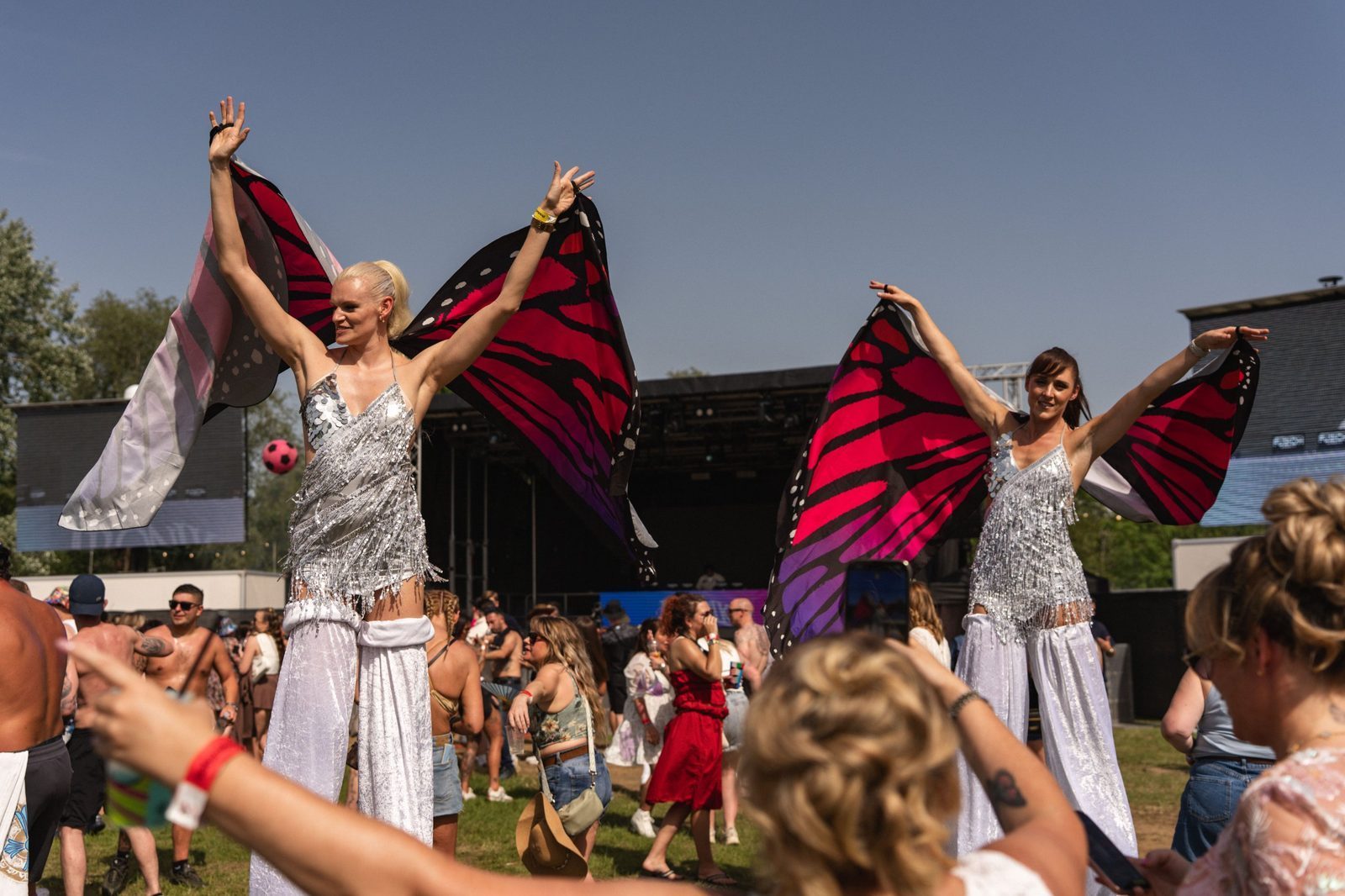 Butterfly stilt walkers in front of the main stage