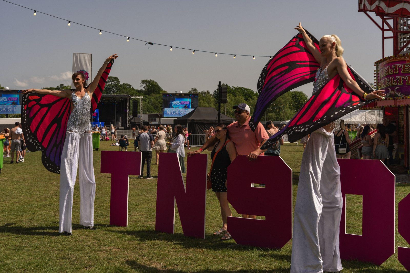 Stilt walkers at the TN90s letters